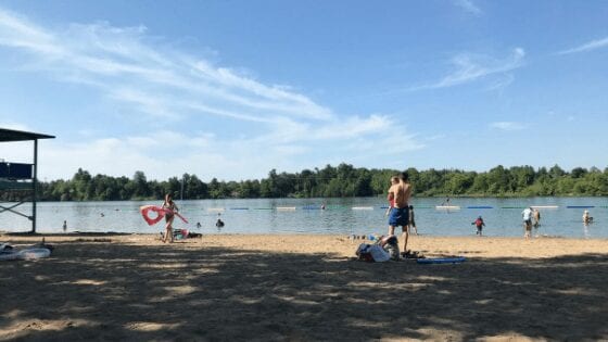 The beautiful white sandy beach of Ottawa Mooneys, with kids playing in the sandy shore.