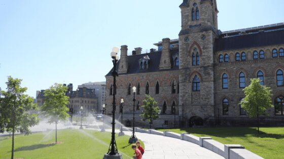 My kids playing outside the Parliament in Ottawa, one of the best things to do in Ottawa with kids.