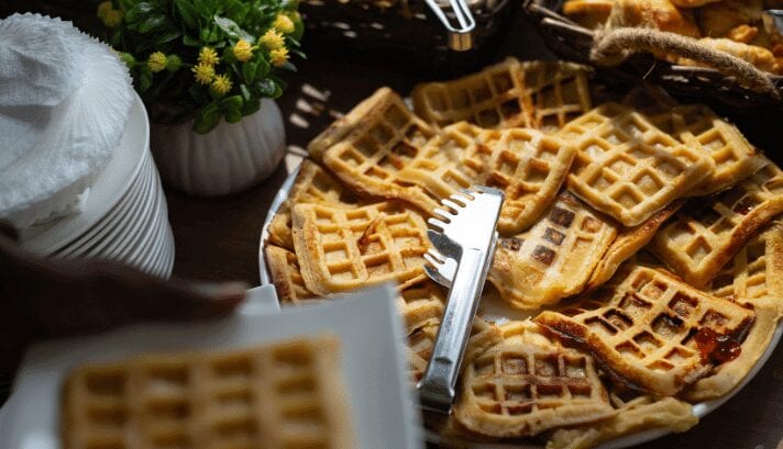 Freshly made Belgian waffles on a plate, golden-brown and crisp, showcased in the bustling atmosphere of Brussels.