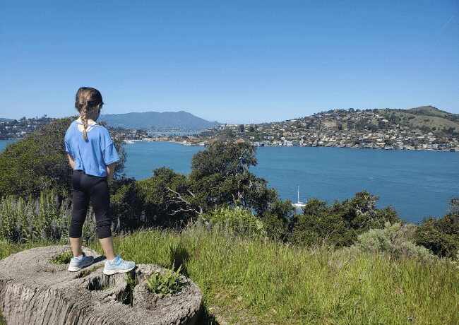A little girl explores the natural beauty of Angel Island State Park, her curiosity leading her to discover hidden treasures and breathtaking vistas on this picturesque island sanctuary in California.