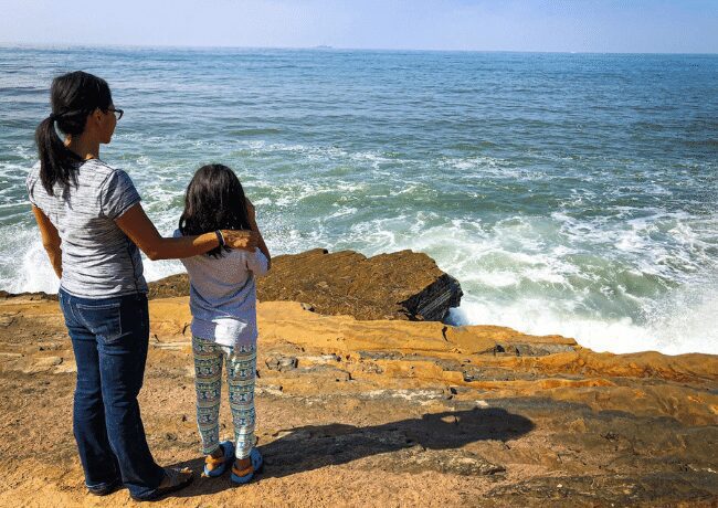 Capture the heartwarming moment of a mother and her child at Cabrillo National Monument in San Diego. Against the backdrop of sweeping ocean views and the historic Old Point Loma Lighthouse, they share a special bond while exploring this iconic coastal park's natural beauty and cultural heritage.
