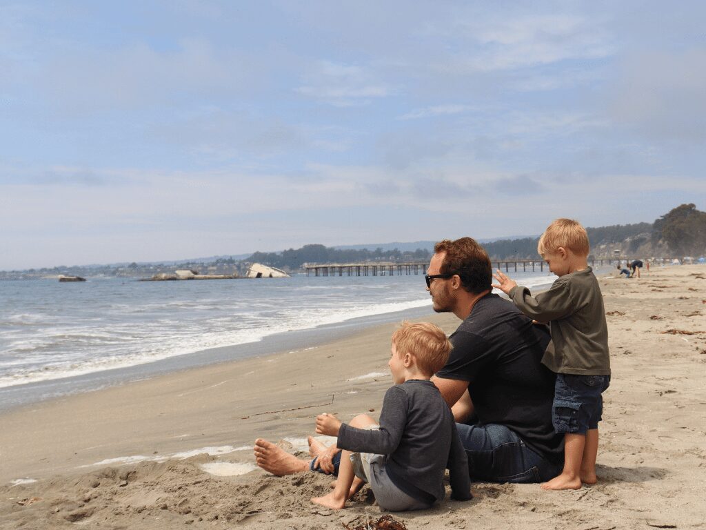 A loving father enjoys a day at the beach with his two children, creating cherished memories together under the warm California sun.
