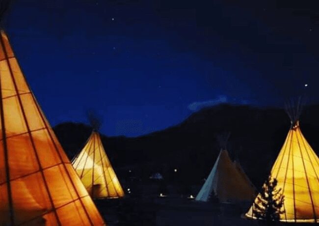 Nighttime at the Dreamcatcher Tipi Hotel. The tipis are all lit up, creating a calm and mystical vibe. 