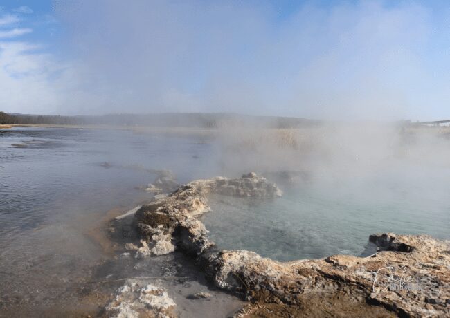 One of the many hot springs in Yellowstone, where visitors can admire the steamy waters and enjoy the therapeutic sights and sounds of nature.