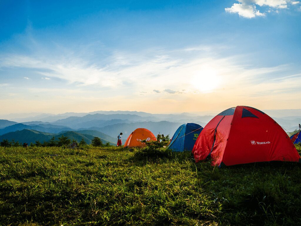 A group of campers using one of the best decathlon tents while camping under a glorious sunrise.