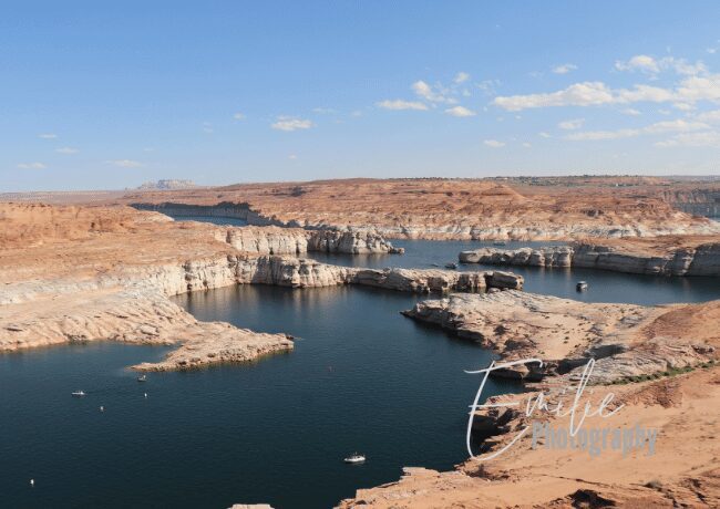 Gaze upon the breathtaking splendor of Lake Powell's panoramic vista, where water and sky blend seamlessly into a masterpiece of nature's design. 
