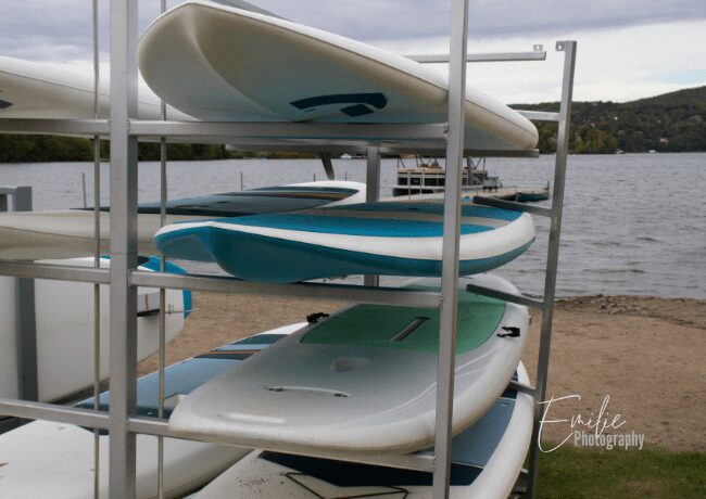 Image of paddleboards on the serene waters of Lac-Beauport, ready for rent. Enjoy a peaceful paddleboarding experience in this beautiful lakeside location.
