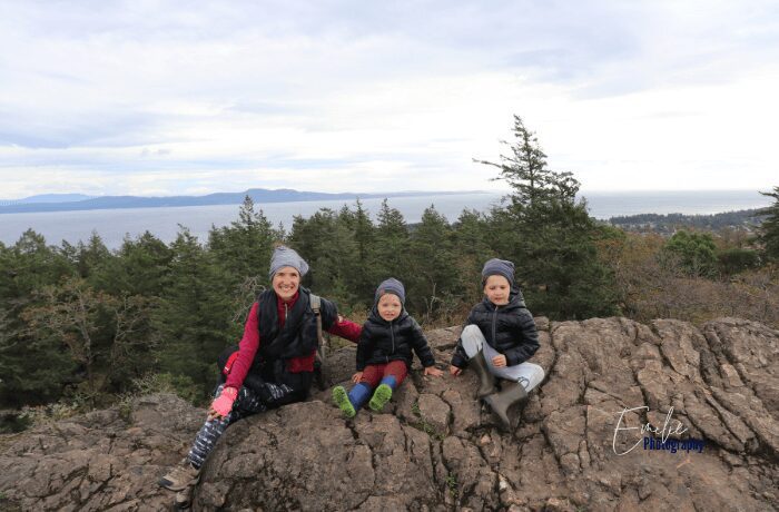 At the summit of Mount Douglas in Victoria, BC, a mother and her two kids are treated to awe-inspiring views. With the city and ocean below, they bond amidst the natural beauty, creating cherished memories that will last a lifetime.