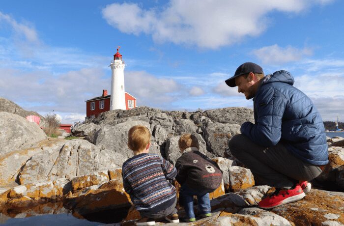 A father and his two kids share a special bonding moment at Fisgard Lighthouse in Victoria, BC. Against the backdrop of this historic maritime icon, they explore the rich marine history of the region, marveling at the towering lighthouse.