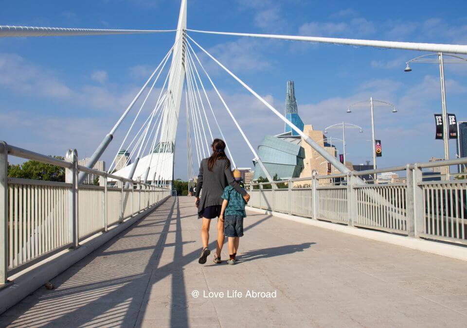 Family walking on he Esplanade Riel having a nice view of the Canadian Museum of Human Rights