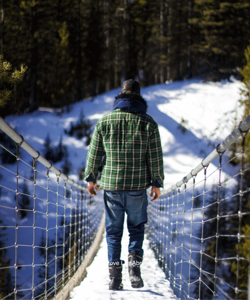 Nathan walking on the Blackshale suspension bridge in the winter