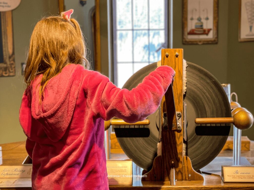 A girl trying a hands-on exhibit at the Bakken Musuem in Minneapolis
